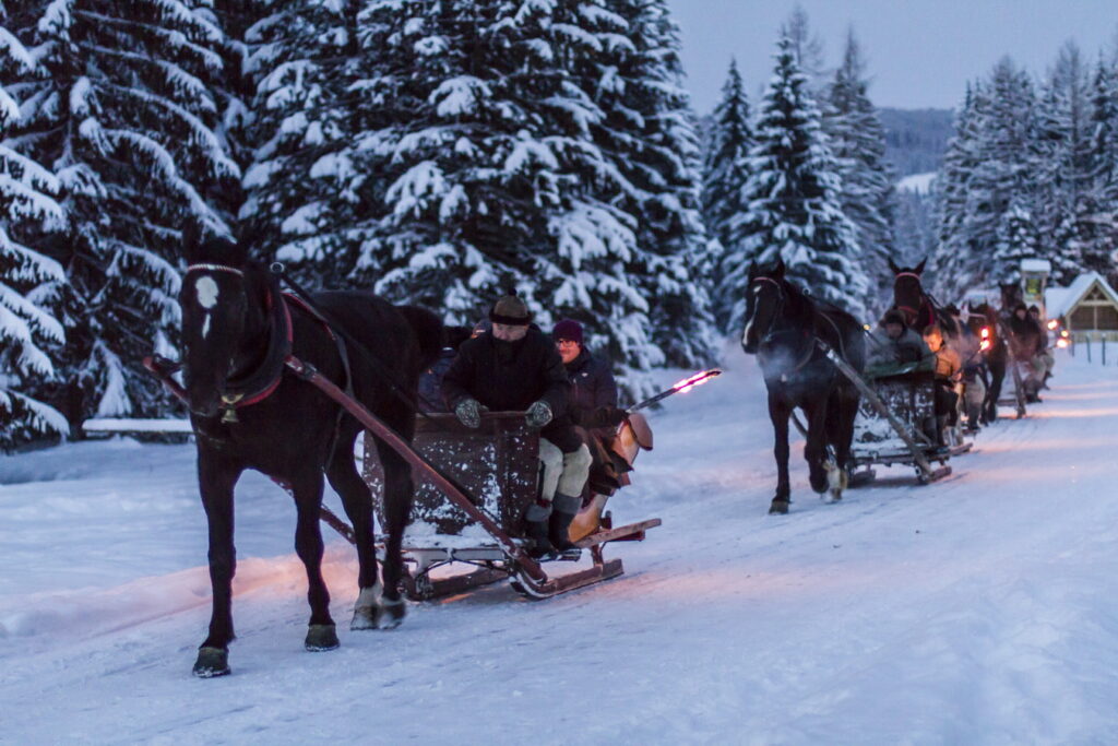 Kulig z pochodniami saniami